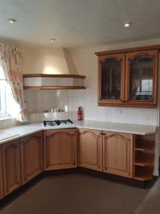 a kitchen with wooden cabinets and a stove top oven at Glenkerry in Ingoldmells