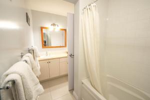 uma casa de banho com um chuveiro e um lavatório. em Luxury Oceanfront Condo by OnlyBC 101 em Tofino