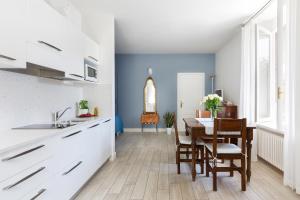 uma cozinha com uma mesa e uma sala de jantar em Villa Maria Apartments em Cannobio