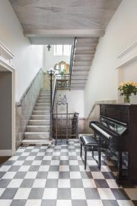 een piano in een kamer met een geruite vloer bij Villa Maria Hotel in Cannobio