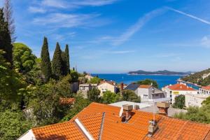 uma vista para uma cidade com telhados laranja e para o oceano em Niki Apartment em Dubrovnik