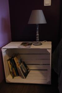 a night stand with a lamp and books on it at Le Verger B&B in Gorron