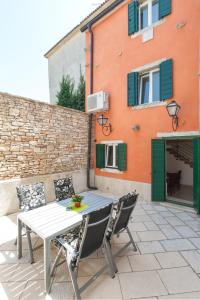 a table and chairs on a patio in front of a building at Casa Bumbara in Vodnjan