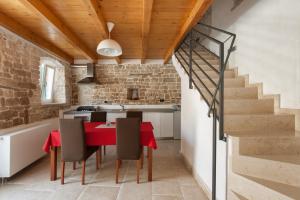 een keuken en eetkamer met een rode tafel en stoelen bij Casa Bumbara in Vodnjan