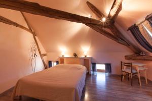 sypialnia z łóżkiem i stołem w pokoju w obiekcie Le Mariecalou w mieście Meloisey