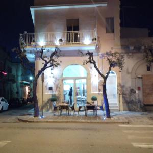 a table and chairs in front of a building at night at B&B miccoli in Grottaglie