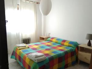 ネルハにあるBright apartmentのベッドルーム1室(カラフルなベッド1台、タオル付)