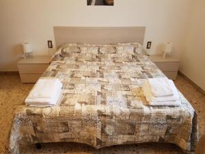 a bedroom with a large bed with two dressers and towels at B&B Buscemi in Pistoia