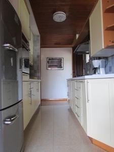 una grande cucina con armadi bianchi e frigorifero di Sunny Garden a Opatija