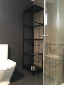 a bathroom with a toilet and a glass shower door at Casa da Fonte in Foz do Arelho +18 photos