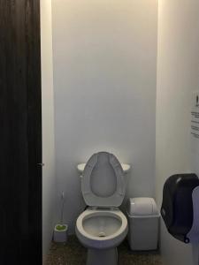a bathroom with a toilet and a trash can at Los Muertos Hostal in Puerto Vallarta