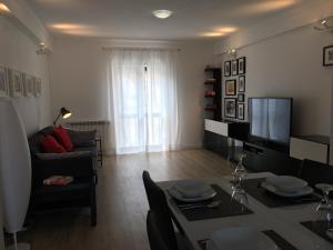 a living room with a couch and a table and a television at Casa da Fonte in Foz do Arelho