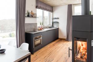 a kitchen with a fireplace and a table with chairs at N8Quartier Eifel in Bad Münstereifel