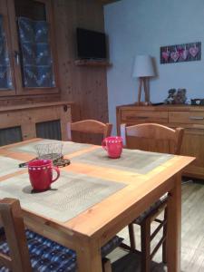 einem Holztisch mit zwei roten Tassen darüber in der Unterkunft Le Foueustarle in La Giettaz