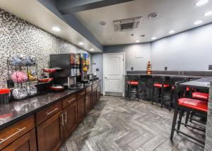 una gran cocina con encimeras negras y taburetes de bar en Hollywood Inn Express LAX, en Inglewood