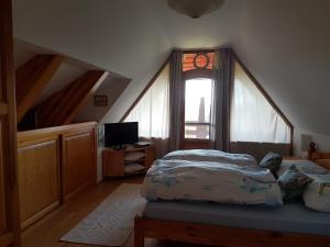 a bedroom with a bed and a large window at Ginavilla in Keszthely