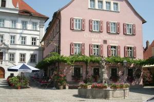 a pink building with a statue in front of it at Gasthof & Hotel Goldene Krone in Iphofen