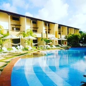 a swimming pool in front of a hotel at Solar Pipa Praia Flats in Pipa