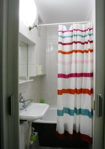 a bathroom with a striped shower curtain and a sink at Praga apartment in Bucharest