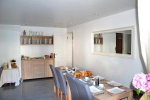 a dining room with a table and blue chairs at Apartamenty & SPA Villa 28 in Pobierowo +36 photos