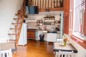 una cucina con due tavoli e una TV a parete di Historic cottage a Rio de Janeiro