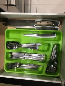 a green tray filled with utensils in a drawer at Widokowy Apartament nad Jeziorem in Olsztyn