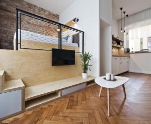 a living room with a bench with a tv on it at Cosy Design Apartment II in Brno