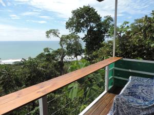 a balcony with a bench and the ocean in the background at Ranchos Remo Lodge in Uvita