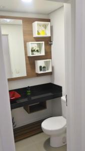 uma casa de banho com um WC branco e um balcão preto em 02 suítes em Capão da Canoa - Ed Maui em Capão da Canoa