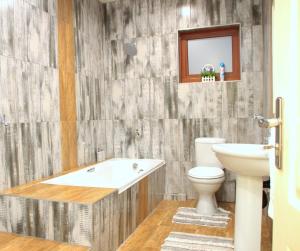 a bathroom with a tub and a toilet and a sink at Green Haven Luxury Apartments in Ezulwini +56 photos