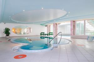 a room with a swimming pool in a building at Hotel Panoramik in Mühlbach