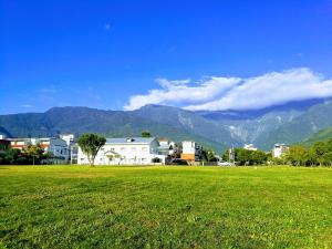 a field of green grass with mountains in the background at Oak Garden in Hualien City