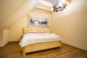 ポロニンにあるApartamenty Baciarskieのベッドルーム1室(ベッド1台付)が備わります。壁には絵画が飾られています。
