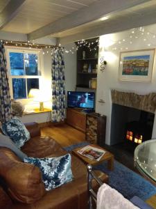 a living room with a couch and a fireplace at Sky Cottage in Fowey