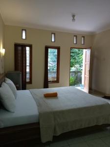 a bedroom with a large bed with a towel on it at Sintya Homestay in Ubud