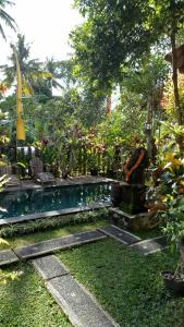 un jardin avec une piscine et quelques plantes dans l'établissement Uma Loris Ubud, à Ubud