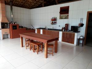 a large kitchen with a wooden table and chairs at Casa em São Tomé das Letras in São Thomé das Letras