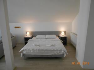 um quarto com uma cama branca e duas mesas de cabeceira em Atocha em Skopje