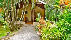 a garden with a walkway in front of a house at Riviera Riverside Villas in Pavones