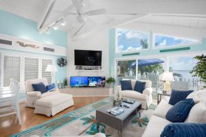 a living room with white furniture and a flat screen tv at Aquarius North in Stuart +56 photos
