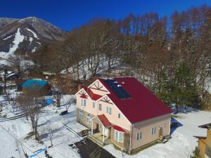 uma vista aérea de uma casa com um telhado vermelho em Pension Himawari em Iizuna