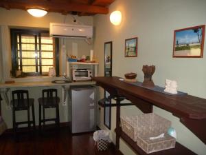 a kitchen with a counter and stools in a room at Sapunaya-さぷな家 in Taketomi