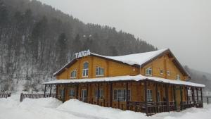 a large wooden house with snow on top of it at Guest House Taiga in Listvyanka