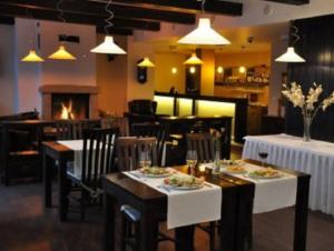 a dining room with tables and chairs and a fireplace at Penzion Chopok - Apartments in Liptovský Mikuláš +62 photos