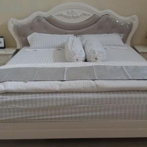 a white bed with white sheets and pillows at Angela Homestay Manado in Tateli