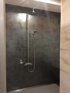 a shower with a shower head in a bathroom at New Bale Motel in Bali