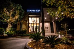 洛坤府Bunprasop Garden Hotel的正面有标志的建筑物