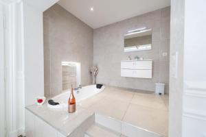 un bagno bianco con vasca e lavandino di La Demeure De Charme a Troyes Altre 118 foto