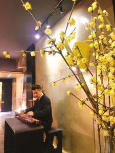 重慶的住宿－漫途高空江景酒店（解放碑洪崖洞夜景店  ) ，坐在植物旁边的桌子上的男人