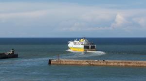 a ferry boat in the water near a pier at Hotel Aguado in Dieppe